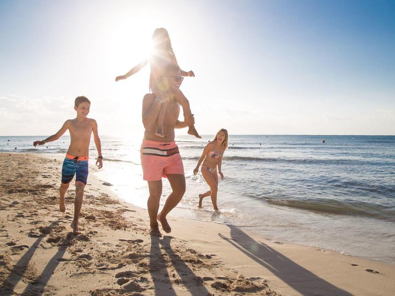 Bambini che giocano su una spiaggia soleggiata vicino al mare.