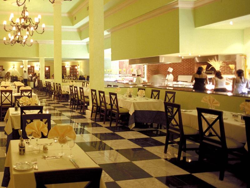 Ristorante luminoso con pavimento a scacchi e tavoli apparecchiati in ambiente alberghiero.