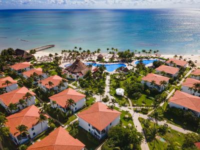 Luxurious resort with red roofs, expansive pool area, and direct access to the sea.