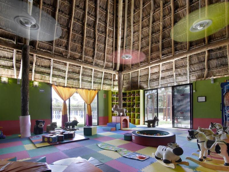 Intérieur coloré d'une salle de jeux pour enfants avec jouets et tapis multicolores.