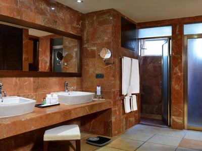 Moderne badkamer met twee wastafels, grote spiegels en glazen doucheruimte.