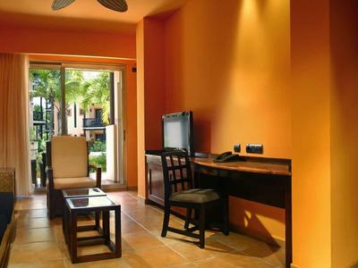 Gezellige hotelkamer met bank, bureau en toegang tot het terras.