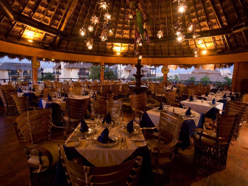 Elegant restaurant met ronde tafels en houten meubels onder een hoog, verlicht dak.