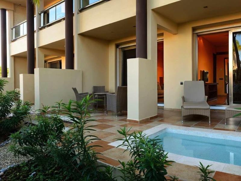 Hotelterras met buitenzitjes en klein privézwembad voor de kamer.