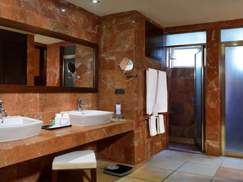 Moderne badkamer met twee wastafels, grote spiegels en glazen doucheruimte.