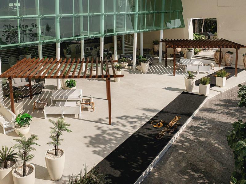 Cortile con pergolati, piante e canale d'acqua in un hotel moderno.