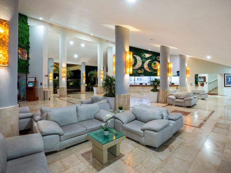 Großer, heller Wartebereich mit grauen Sofas, Glas-Tischen und modernen Wandlampen.