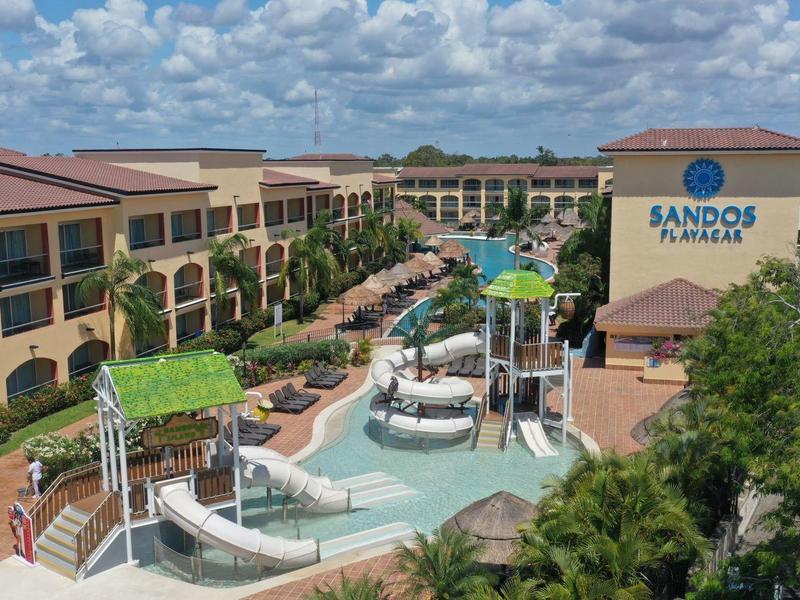 Grande resort con più piscine, scivoli d'acqua e cielo soleggiato.