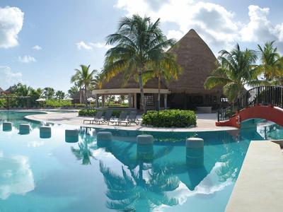 Resort mit Pool, Palmen und Strohdachbungalows unter blauem Himmel