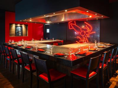 Spazio ristorante elegante con decorazioni rosse e nere e ampi posti a sedere al bancone.