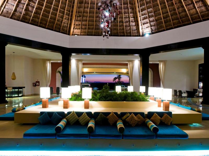 Lussuosa hall d'hotel con ampie sedute e illuminazione elegante sotto un alto soffitto di legno.