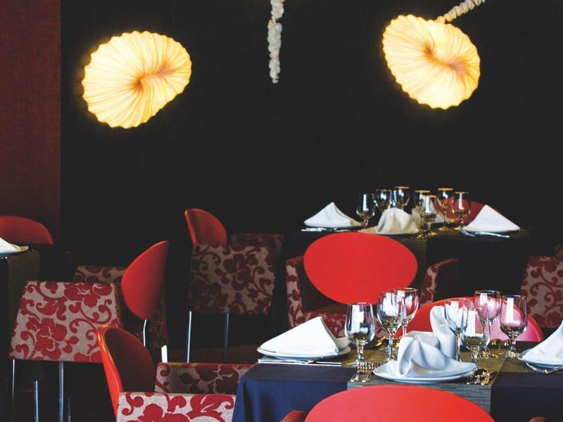 Ristorante con sedie rosse e decorazione a stella marina sulla parete