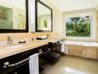 Helles Badezimmer mit großem Fenster, Doppelwaschbecken, Marmorarbeitsplatte und Badewanne mit Naturblick.
