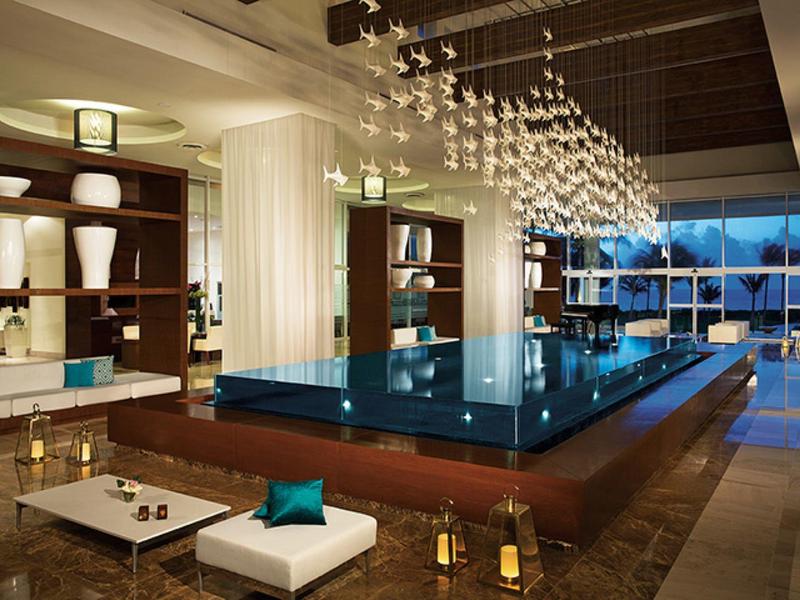 Piscina interna moderna con posti a sedere, grandi finestre e illuminazione elegante in un hotel di lusso.