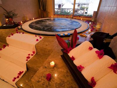 Vasca idromassaggio tonda interna con asciugamani e candele per un'atmosfera rilassante.