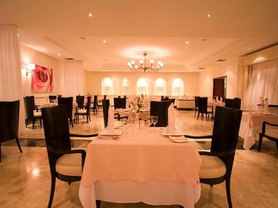 Ristorante elegante con tavoli apparecchiati e illuminazione festosa.