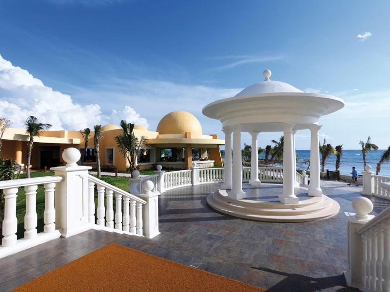 Ampia terrazza dell'hotel con gazebo bianco, ringhiere a balaustra e vista sul mare.