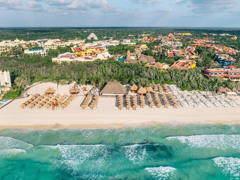Vista panoramica della spiaggia con lettini e resort sullo sfondo