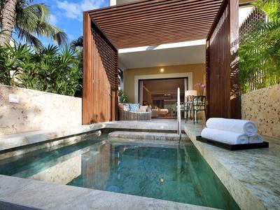 Piscina privata moderna con asciugamani, circondata da muri in pietra e vegetazione lussureggiante.