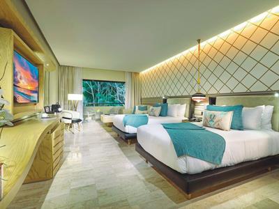 Camera d'hotel moderna con due letti grandi e vista sulla natura.