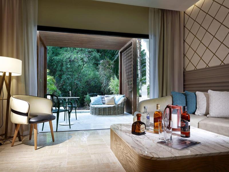 Camera d'hotel moderna con accesso a terrazza verde e arredamento elegante.