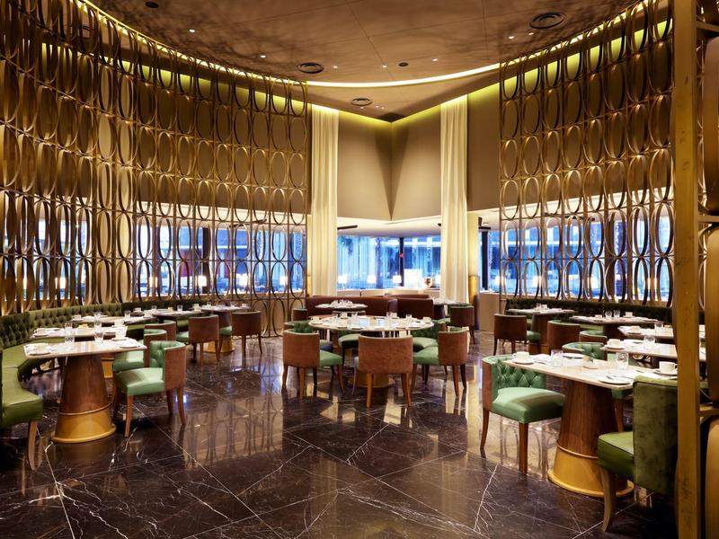 Sala da pranzo elegante con sedie verdi e decorazioni dorate lussuose.