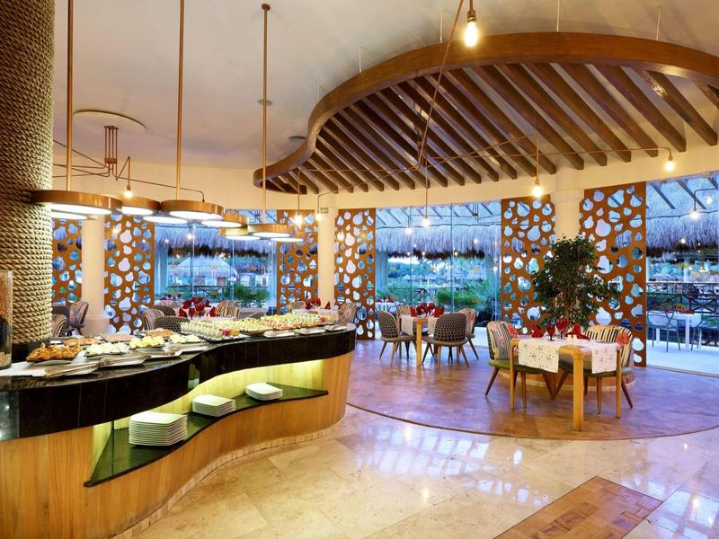 Ristorante elegante in hotel con arredamento moderno e grandi finestre affacciate sulla terrazza.