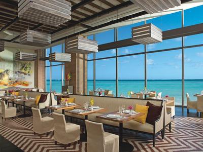 Modern restaurant with sea view, large windows, and stylish interior design.