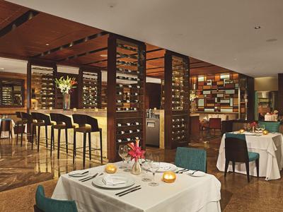 Elegant restaurant with wood accents, wine racks, and set tables for a luxurious dinner.