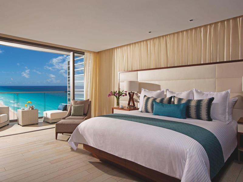 Luxurious bedroom with large bed and ocean view through floor-to-ceiling windows