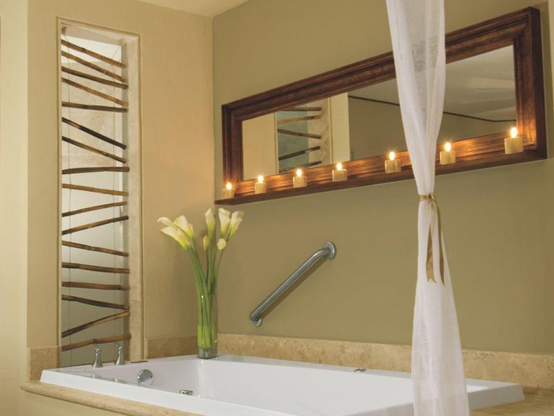 Elegantní vana s svíčkami, závěsem a květinami ve stylové koupelně.