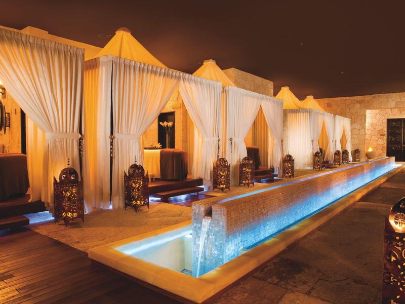 Eleganti padiglioni a tenda vicino alla piscina illuminata di notte con un'atmosfera calda in un hotel.