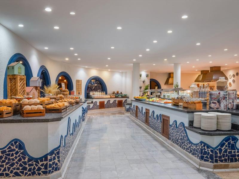 Ampia sala colazione con ampia scelta di prodotti da forno e arredi moderni e luminosi.