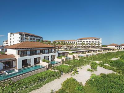 Großes Hotelresort mit mehreren Gebäuden und einem Pool unter blauem Himmel.