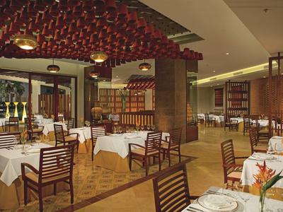 Elegantes Restaurant mit weißen Tischdecken und Holzmöbeln in warmem Licht.