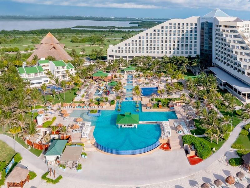 Duży ośrodek z basenem, palmami i unikalnymi architektonicznie hotelami przy wybrzeżu.