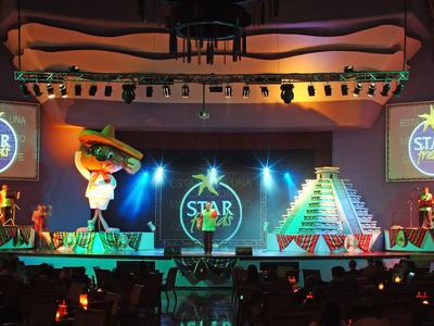 Scena z kolorowymi strojami i dekoracjami podczas uroczystego wydarzenia.