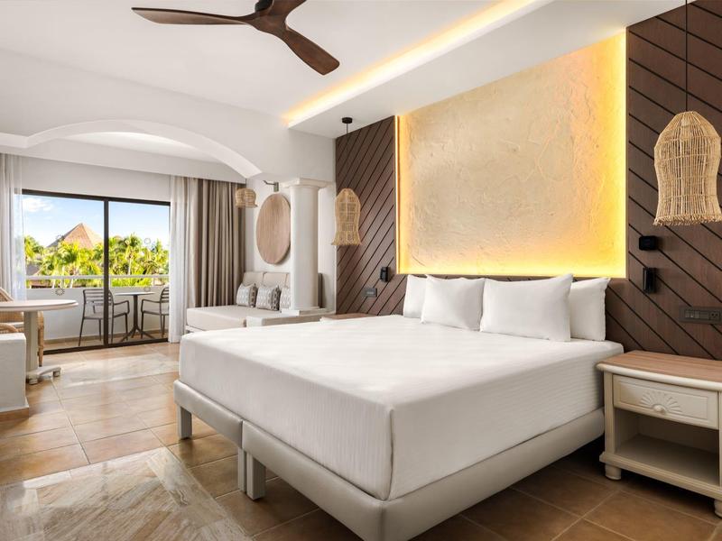 Camera d'hotel moderna con letto grande, balcone e illuminazione calda