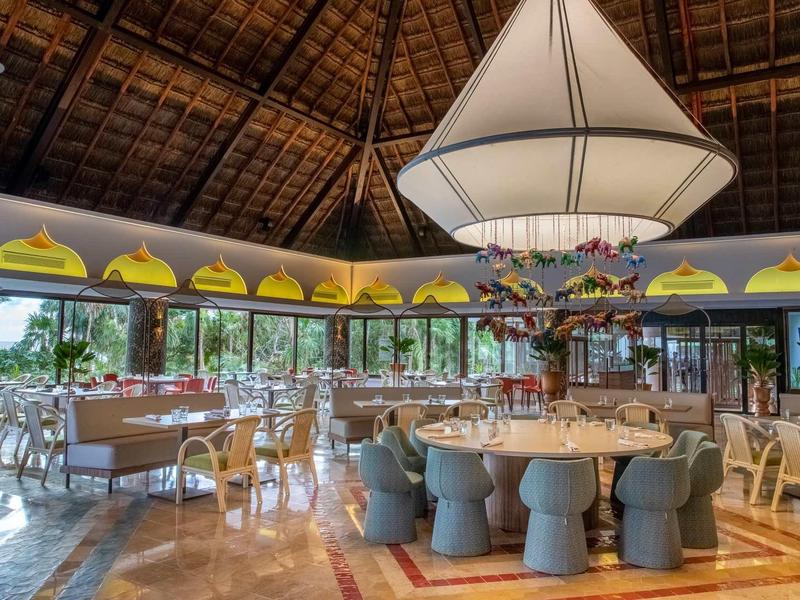 Elegante sala da pranzo dell'hotel con soffitto alto in legno e arredamento moderno.