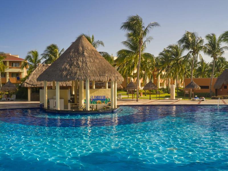 Grande piscina con bar in piscina e palme in resort tropicale