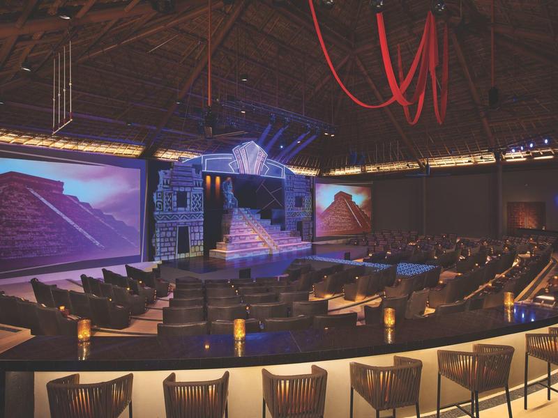 Palco teatrale in una sala moderna con posti a sedere e illuminazione atmosferica