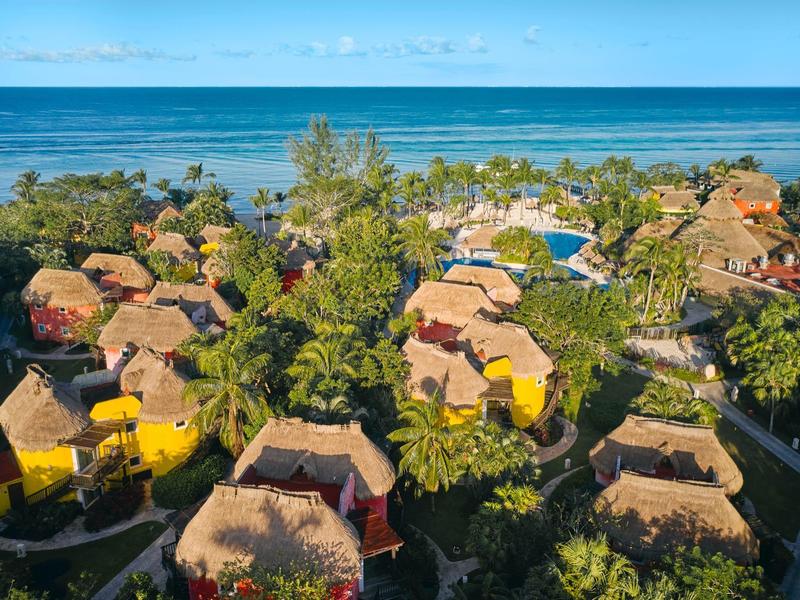 Bungalow con tetti di paglia in un resort tropicale sulla spiaggia con vista sul mare.