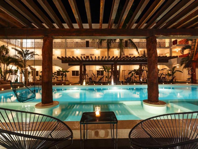 Piscina interna illuminata con posti a sedere e atmosfera calda in un hotel.