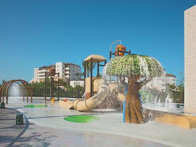 Parco acquatico giochi vuoto con scivoli e giochi d'acqua sotto un cielo azzurro limpido.