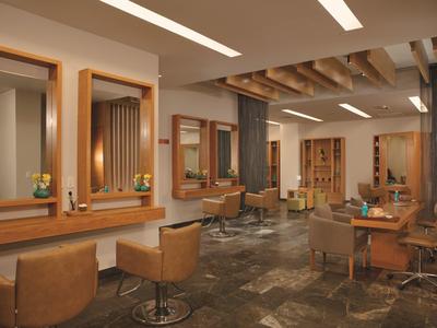 Salone moderno con poltrone in pelle, specchi in legno e pavimento in pietra.