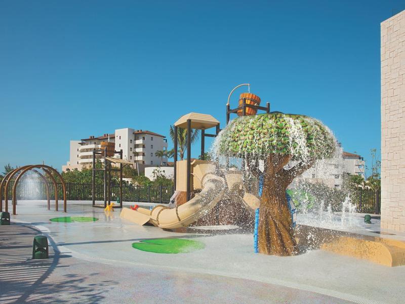 Parco acquatico giochi vuoto con scivoli e giochi d'acqua sotto un cielo azzurro limpido.