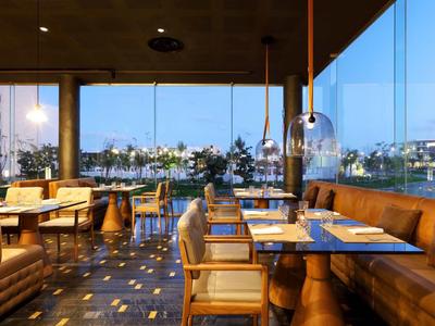 Ristorante moderno con mobili in legno e grandi finestre con vista su acqua e città