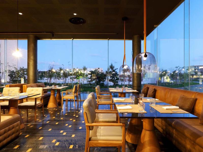 Ristorante moderno con mobili in legno e grandi finestre con vista su acqua e città