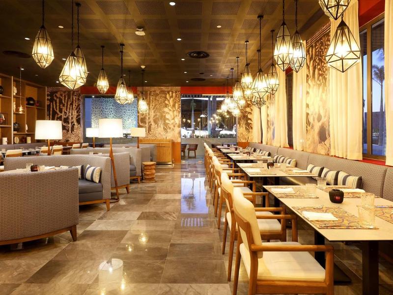 Ristorante d'hotel moderno con mobili in legno eleganti e illuminazione calda.