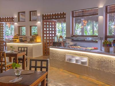 Modern eingerichtetes Restaurant mit Holzmöbeln und großen Fenstern, das zum Hotelurlaub einlädt.